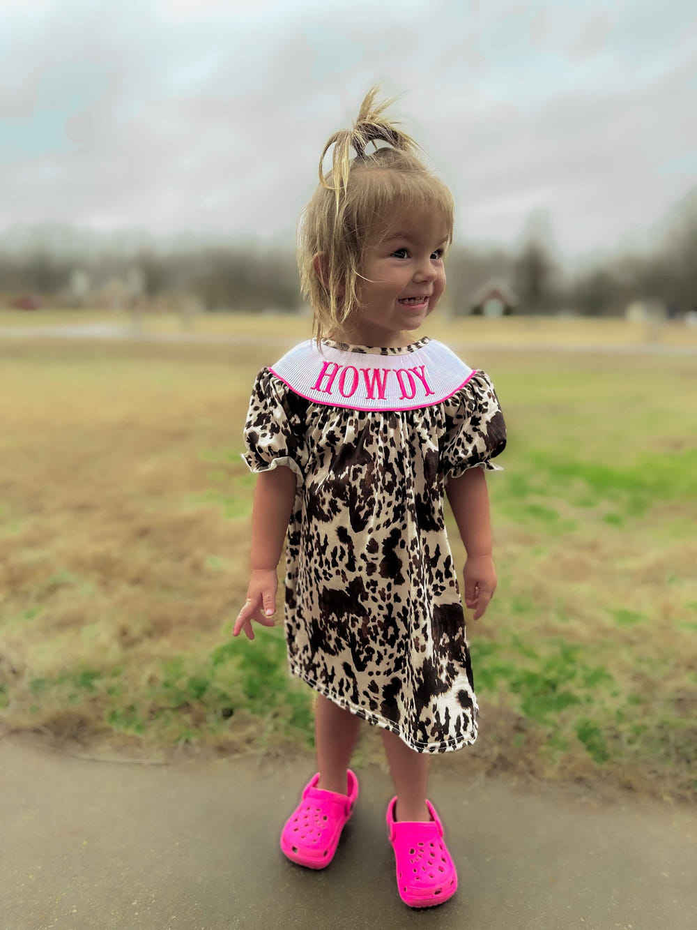 Smocked cowhide howdy dress for babies, stylish and comfortable clothing for little ones.