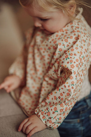 Smock Bib in Sunset Meadow design, perfect for mess-free feeding and playful mealtime adventures.