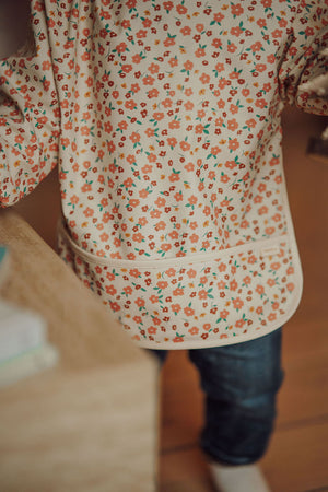 Smock Bib in Sunset Meadow design, perfect for messy mealtimes, shown from angle 6.