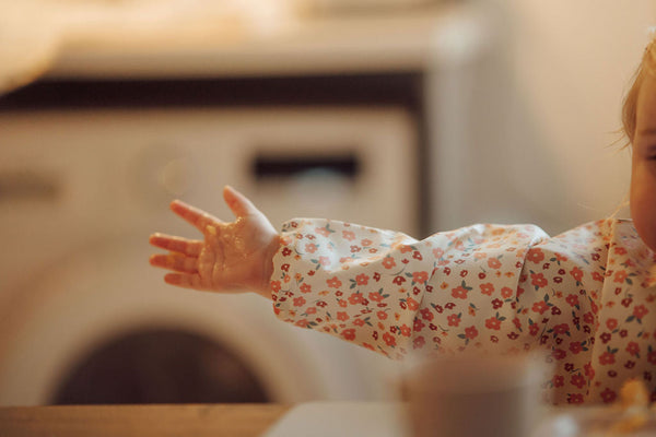 Smock Bib in Sunset Meadow design, showcasing vibrant colors and patterns, perfect for messy mealtimes.