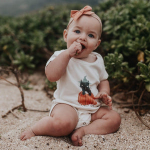 Graphic bodysuit for babies featuring "My First Halloween" cat design, short sleeve, angle view.