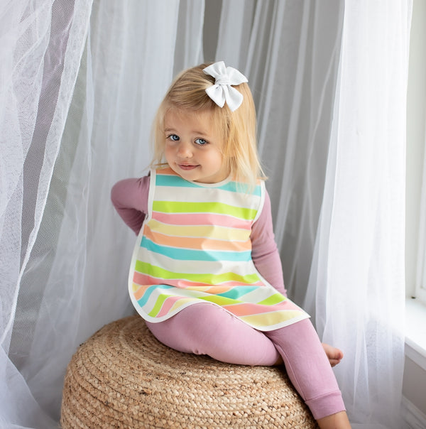 Rainbow Stripes Bapron for babies, angled view showcasing vibrant colors and playful design. Perfect for mealtime messes.