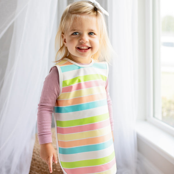 Rainbow Stripes Bapron for babies, angled view showcasing vibrant colors and practical design for mealtime messes.