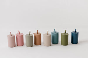 Toddler cups with straw in vibrant colors, perfect for little hands and spill-free sipping. Angle view.