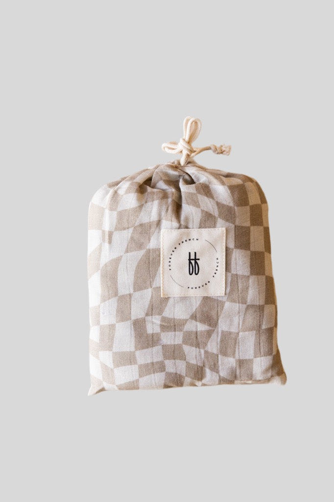 Muslin crib sheet in wavy checker pattern, perfect for stylish and comfortable nursery bedding.