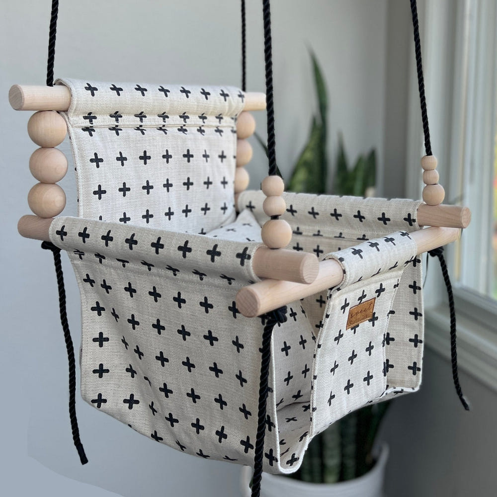 Swiss Cross Oatmeal and Black Indoor Swing for babies, stylish and comfortable for playtime and relaxation.