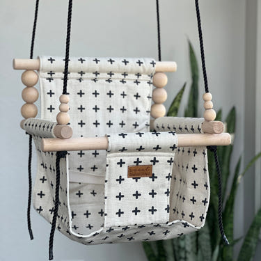 Swiss Cross Oatmeal and Black Indoor Swing for babies, stylish and comfortable for playtime and relaxation.