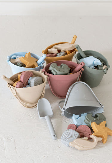 Silicone sand bucket set with toys and shovel for beach fun, perfect for toddlers and kids.