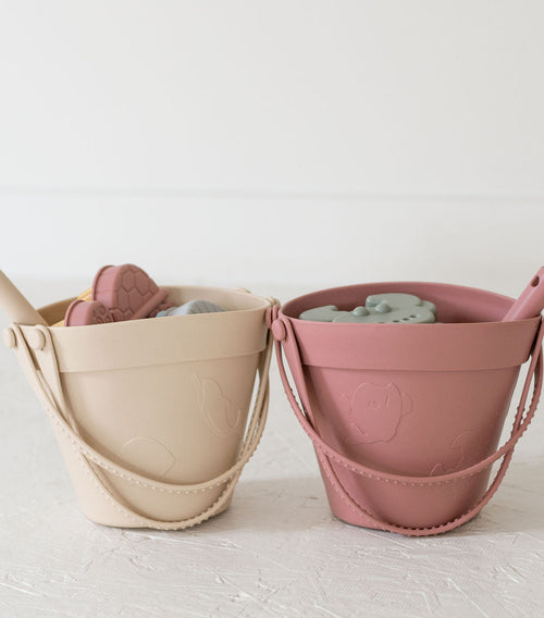 Silicone sand bucket with toys and shovel, perfect for beach fun and outdoor play. Angle 2 view.