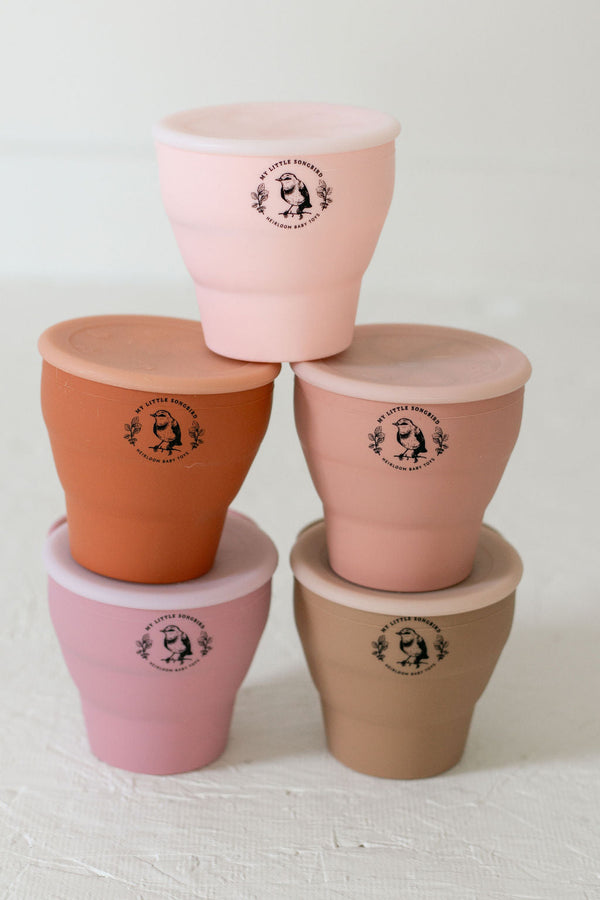 Silicone snack cups in various colors, collapsible design for easy storage, perfect for toddlers and snacks on-the-go.