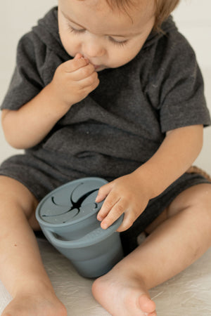 Silicone snack cups in various colors, collapsible design for easy storage, perfect for baby snacks.