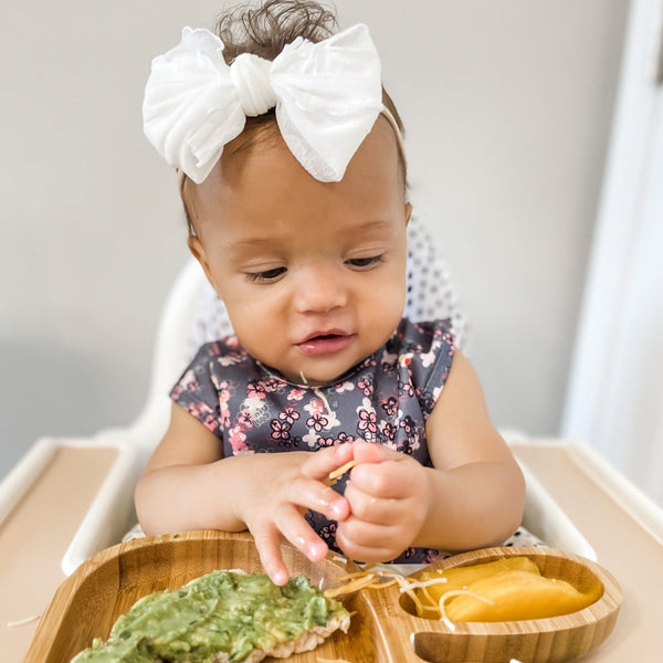 Ditsy Floral Bapron for babies, angled view showcasing vibrant floral pattern and practical design.