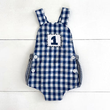 Navy blue smocked sunsuit for baby boys, perfect for first birthday celebrations.