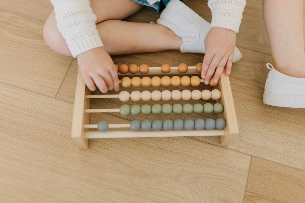 Neutral wooden abacus for babies, promoting health and safety through early learning and development.