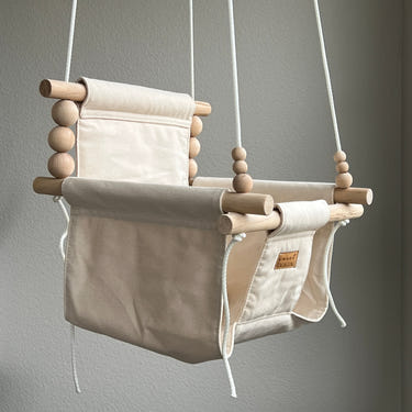 Vanilla indoor baby swing, cozy and stylish, perfect for soothing your little one.