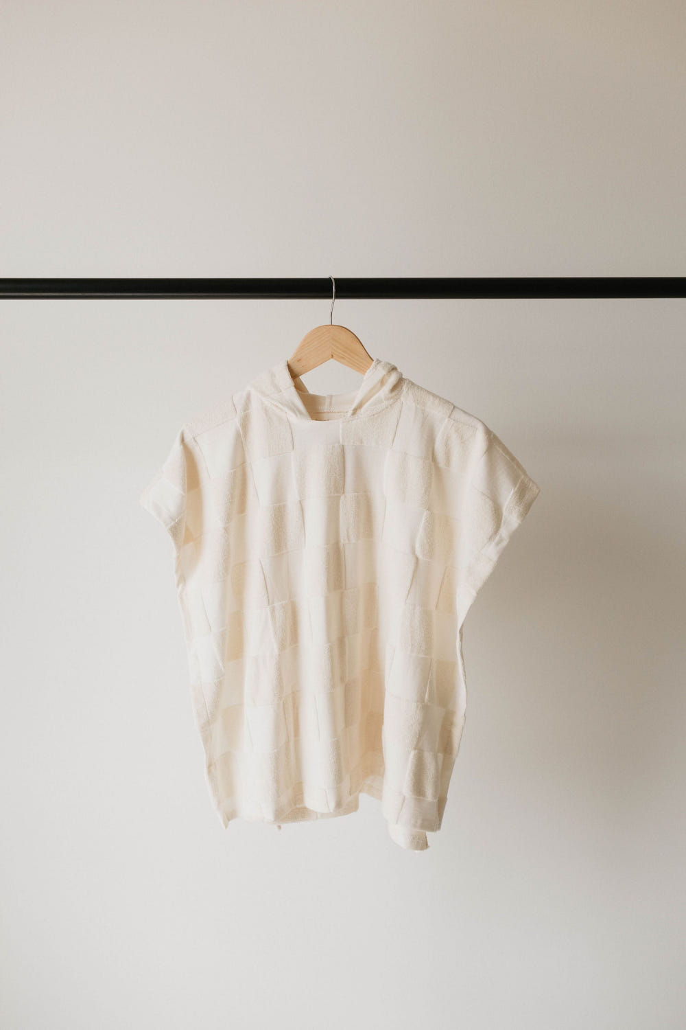 Cream checkerboard hooded towel for babies, soft and cozy for bath time.