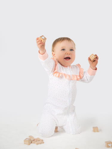 Organic cotton pink polka dot ruffled romper for babies, perfect for stylish and comfortable playtime.