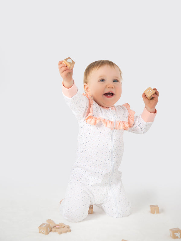Organic cotton pink polka dot ruffled romper for babies, perfect for stylish and comfortable playtime.