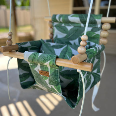 Outdoor tropical leaf swing for babies, perfect for fun and relaxation in the sun.