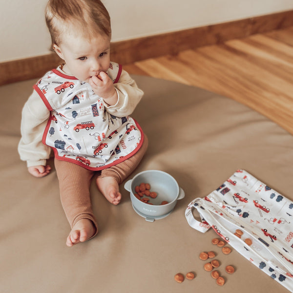 "Be Brave Firefighter Bapron for babies, angled view showcasing fun design and practical use."