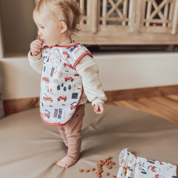 "Be Brave Firefighter Bapron for babies, angle view showcasing fun design and practical use."