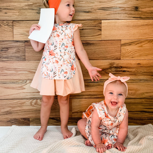 Peachy Dreams Bapron for babies, angle view showcasing its soft fabric and playful design. Perfect for mealtime messes.