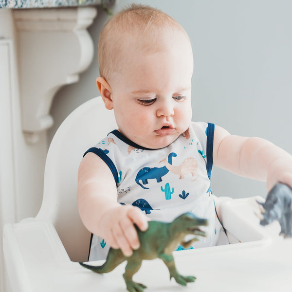 Desert Dinos Bapron for babies, angle view showcasing fun dinosaur print and practical design for mealtime messes.