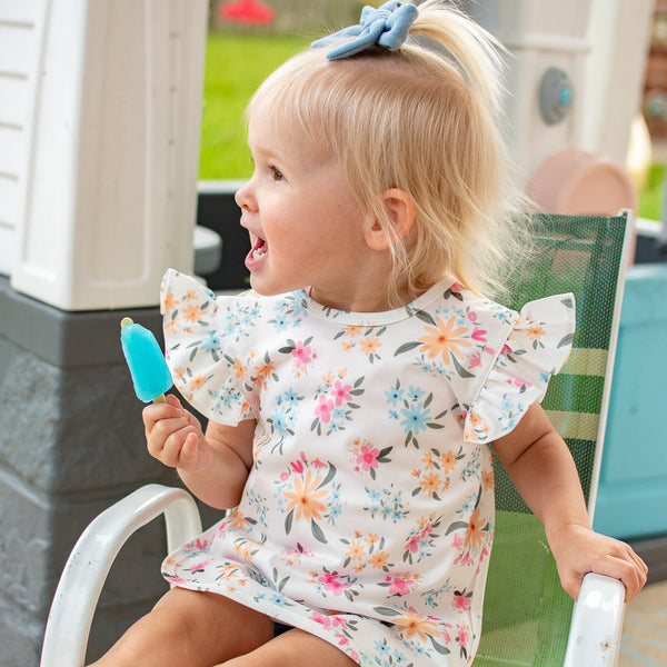 Pastel Floral Flutter Bapron for babies, angled view showcasing vibrant colors and playful design.