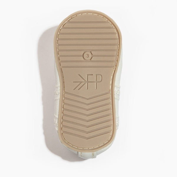 Ivory lace ballet slipper baby shoe, angle view showcasing delicate design and soft materials for little dancers.