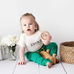 Graphic bodysuit for babies in 'Lucky' design, short sleeves, angle view showcasing vibrant colors and playful style.