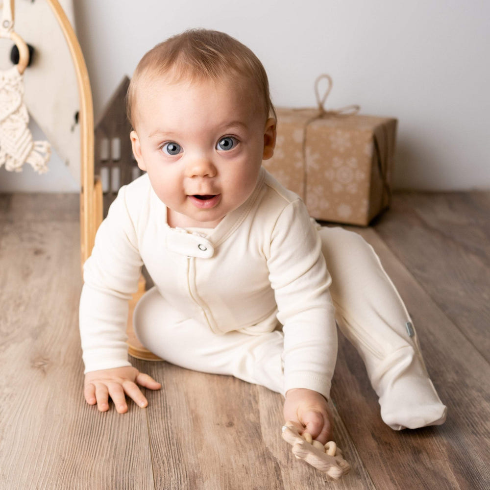 Ivory baby footie one-piece, soft and cozy for infants, perfect for everyday wear.