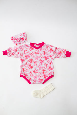 Pink Bows Bubble Romper for babies, featuring a cute design and comfortable fit, angled view showcasing details.