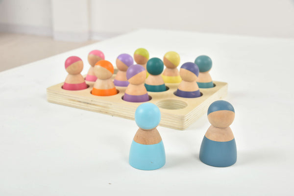 Wooden rainbow peg dolls set, 12 colorful figures for indoor play, displayed at a 10-degree angle.