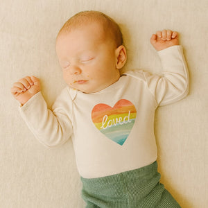 Long sleeve graphic bodysuit featuring a loved rainbow heart design, perfect for babies. Angle 2 view.