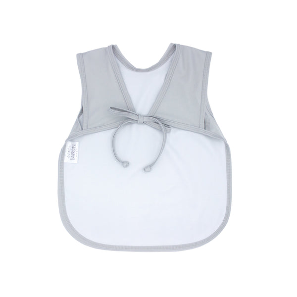 Solid light gray minimalist bapron for babies, angled view showcasing its sleek design and functionality.