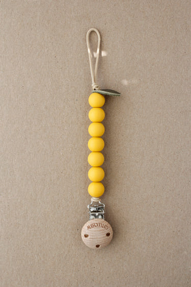 Lemon-themed pacifier clip for babies, ensuring comfort and style while keeping pacifiers secure.