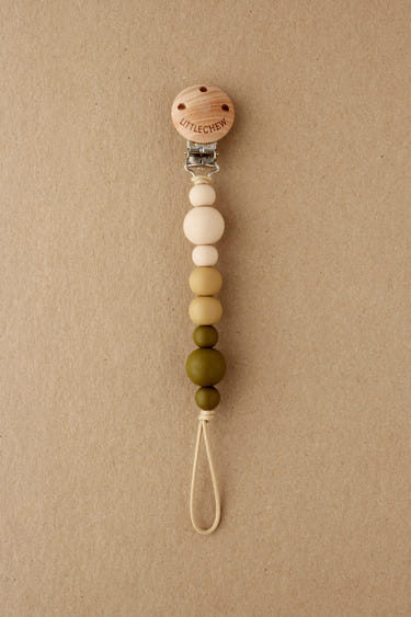 Pacifier Clip - Kira in Moss color, stylish and functional baby accessory for keeping pacifiers close.
