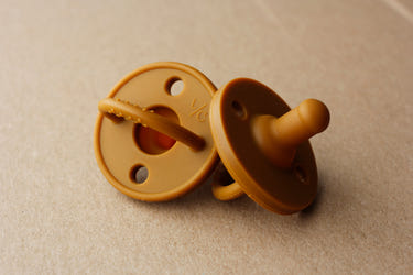 Silicone pacifier in clay color, safe and stylish for soothing babies. Perfect for comfort and teething relief.