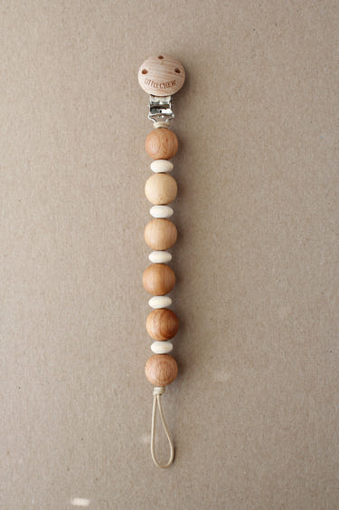Kozuk pacifier clip in vibrant colors, securely holding a pacifier for babies.