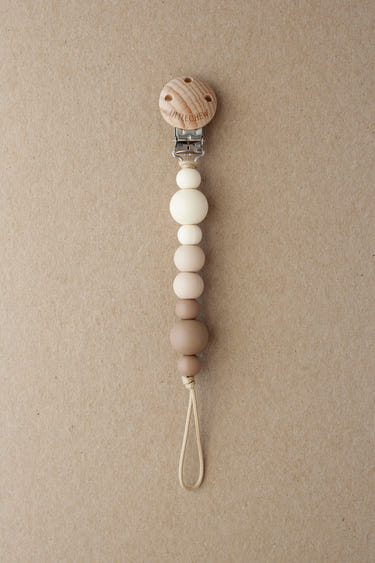 Kira Truffle Pacifier Clip - Stylish and functional baby accessory for keeping pacifiers close and clean.