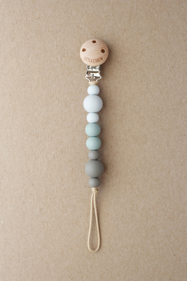 Grey Kira Pacifier Clip for babies, stylish and functional accessory to keep pacifiers within reach.