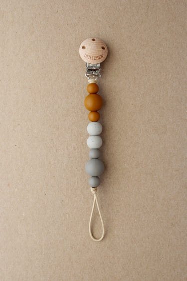 Pacifier Clip - Kira in Dune color, perfect for keeping pacifiers secure and stylish for your baby.