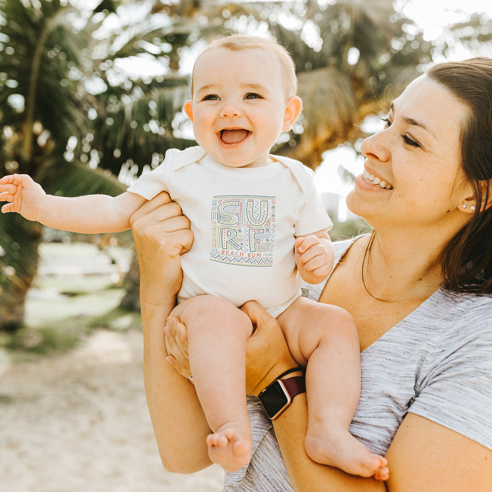 Graphic bodysuit for babies featuring a fun surf design, perfect for summer outings. Short sleeve comfort and style.