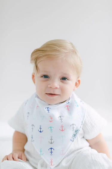 "Shore Set bandana bibs for babies featuring anchors, flowers, flamingos, and boats in vibrant colors."