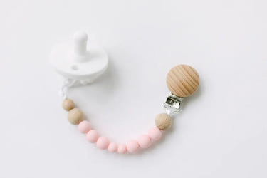 Pink pacifier clip for babies, ensuring pacifier stays clean and within reach. Perfect for stylish and practical use.