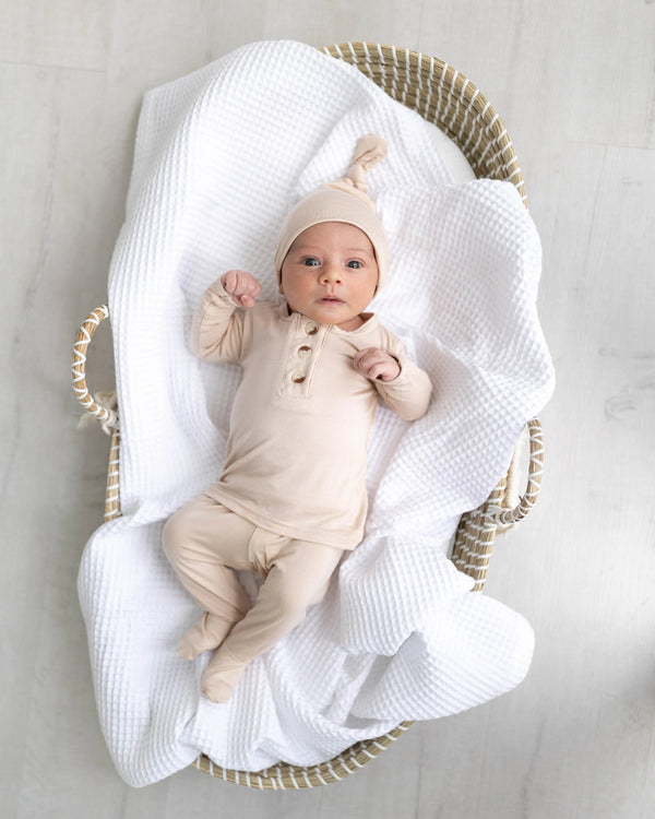 Gender-neutral newborn top and bottom outfit set in sand color, perfect for stylish and comfortable baby wear.