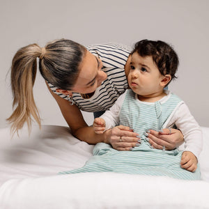 One & Done Sleep Sack in green stripes, angle view showcasing cozy design for babies.