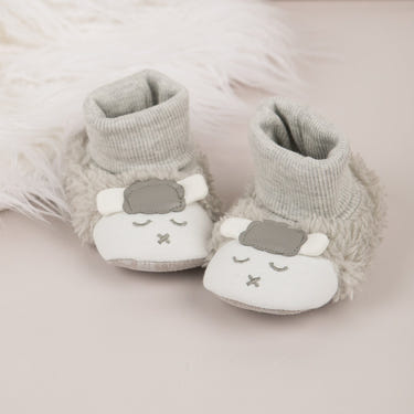 Soft "Baby's First" lamb booties for infants, perfect for cozy comfort and adorable style.