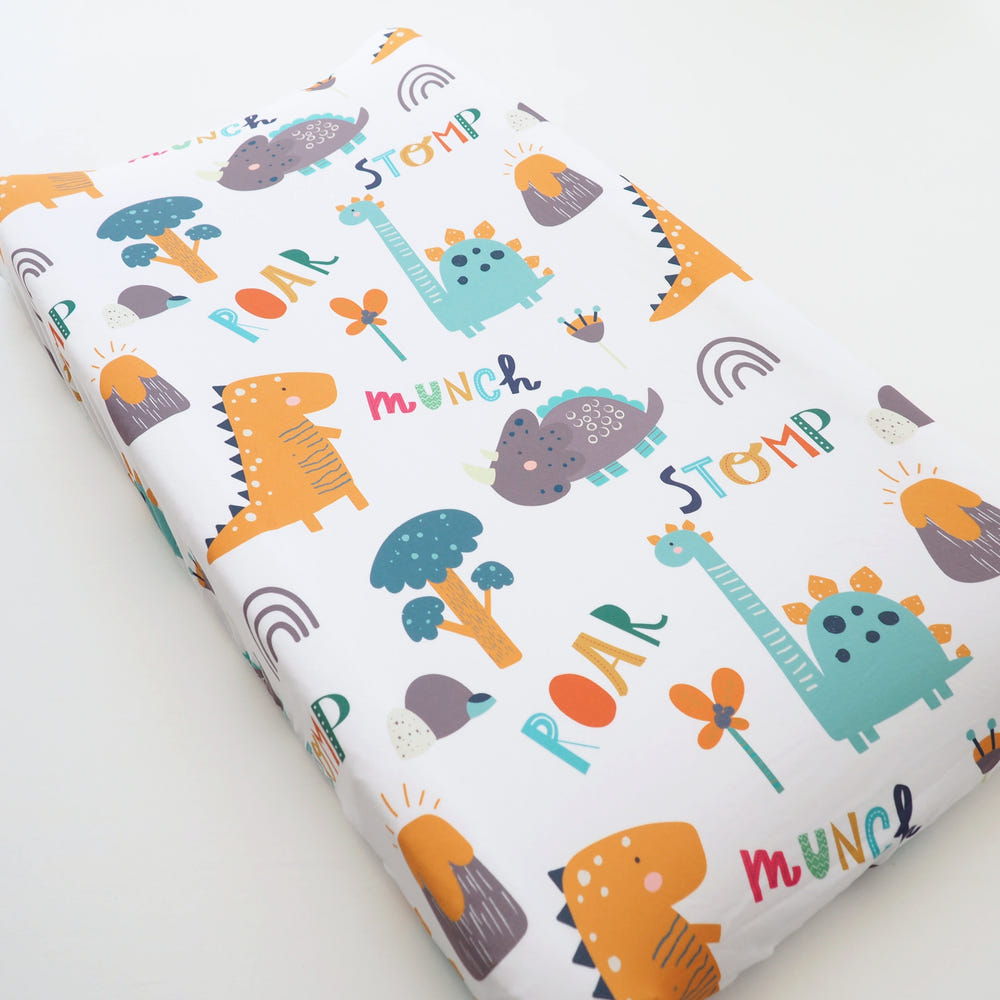 Dinoland changing pad cover for babies, featuring a playful dinosaur design, perfect for nursery decor.