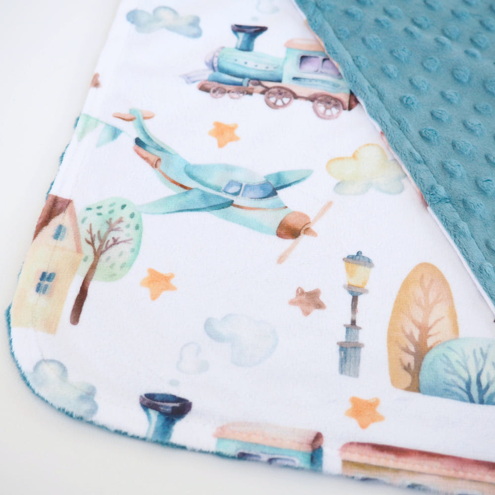 Mini Minky Blanket featuring colorful airplane and train designs for babies, soft and cozy for comfort.
